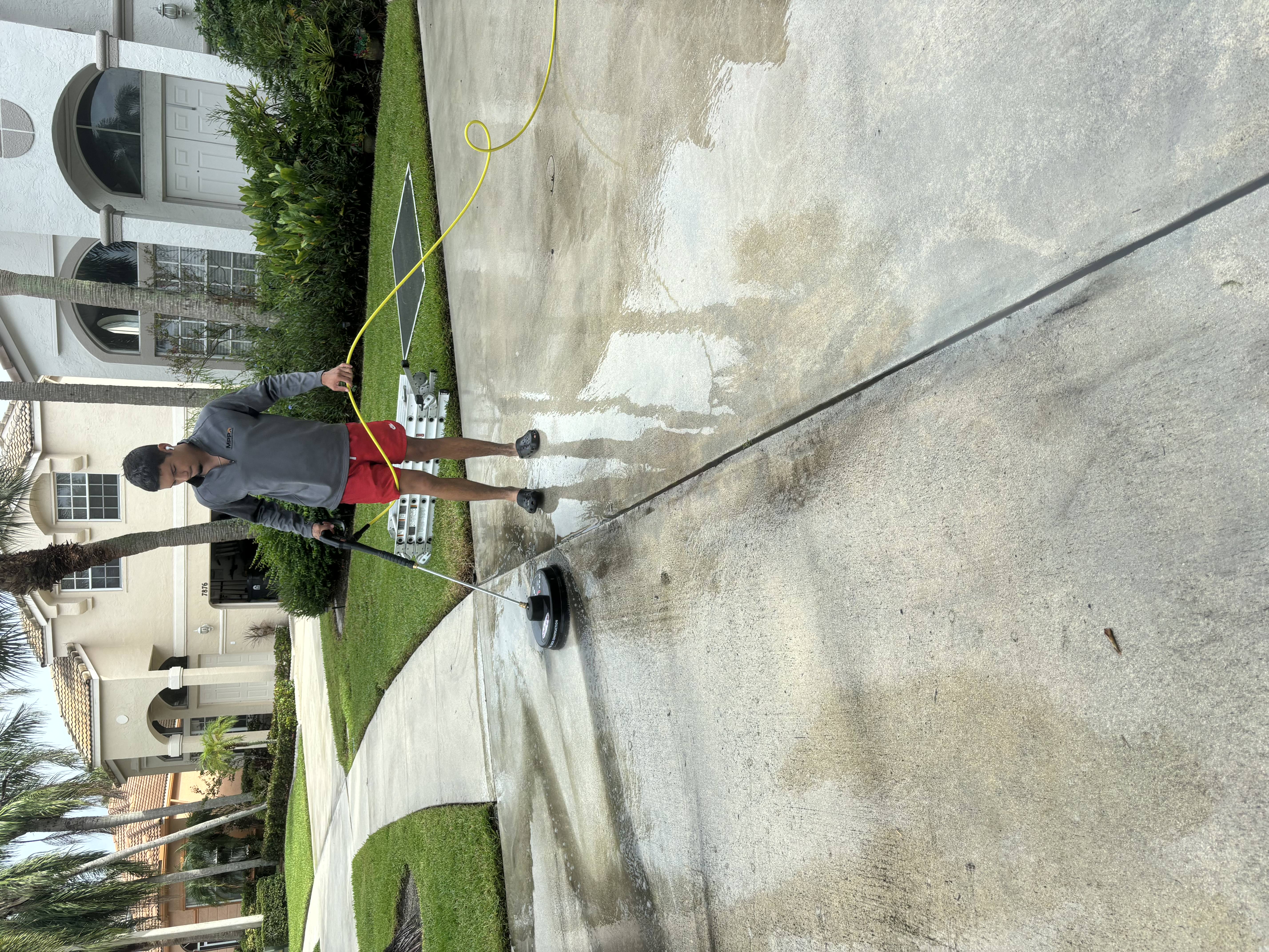 Pressure washing a driveway to remove dirt and grime
